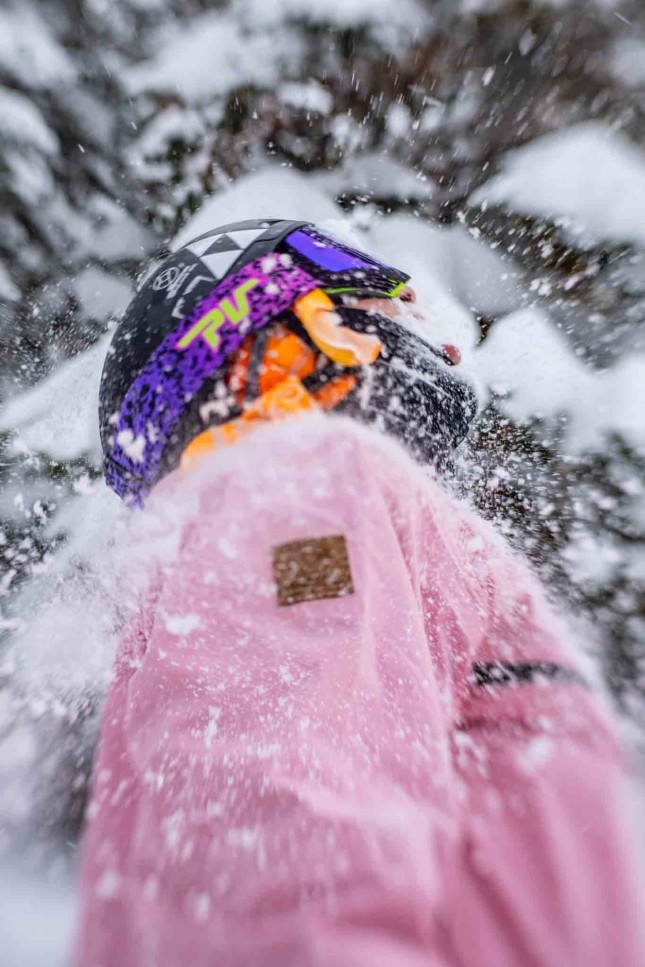 Skier in a pink jacket with a snowy background