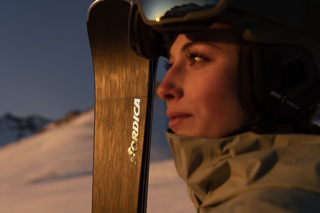 Close up of a female holding a pair of Nordica skis